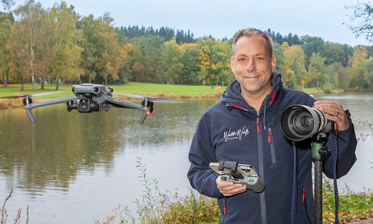 Geschäftskunden - Fotograf Weiss mit Kamera und Drohne vor dem Germeringer See