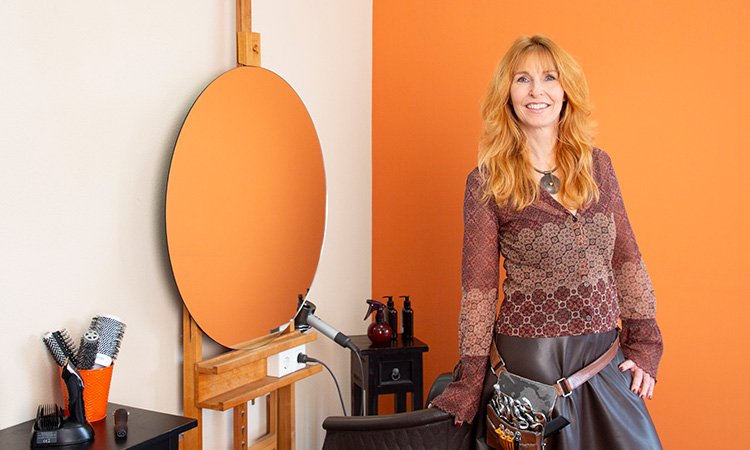 Geschäftskunden - Friseurmeisterin Stefanie Schüll vor Spiegel mit Friseur-Utensilien