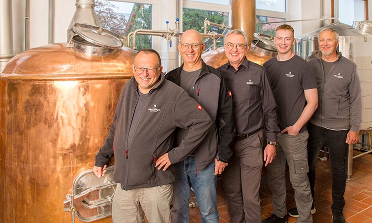 Geschäftskunden - Brauhaus Germering, Team steht in Brauhaus vor Braukessel